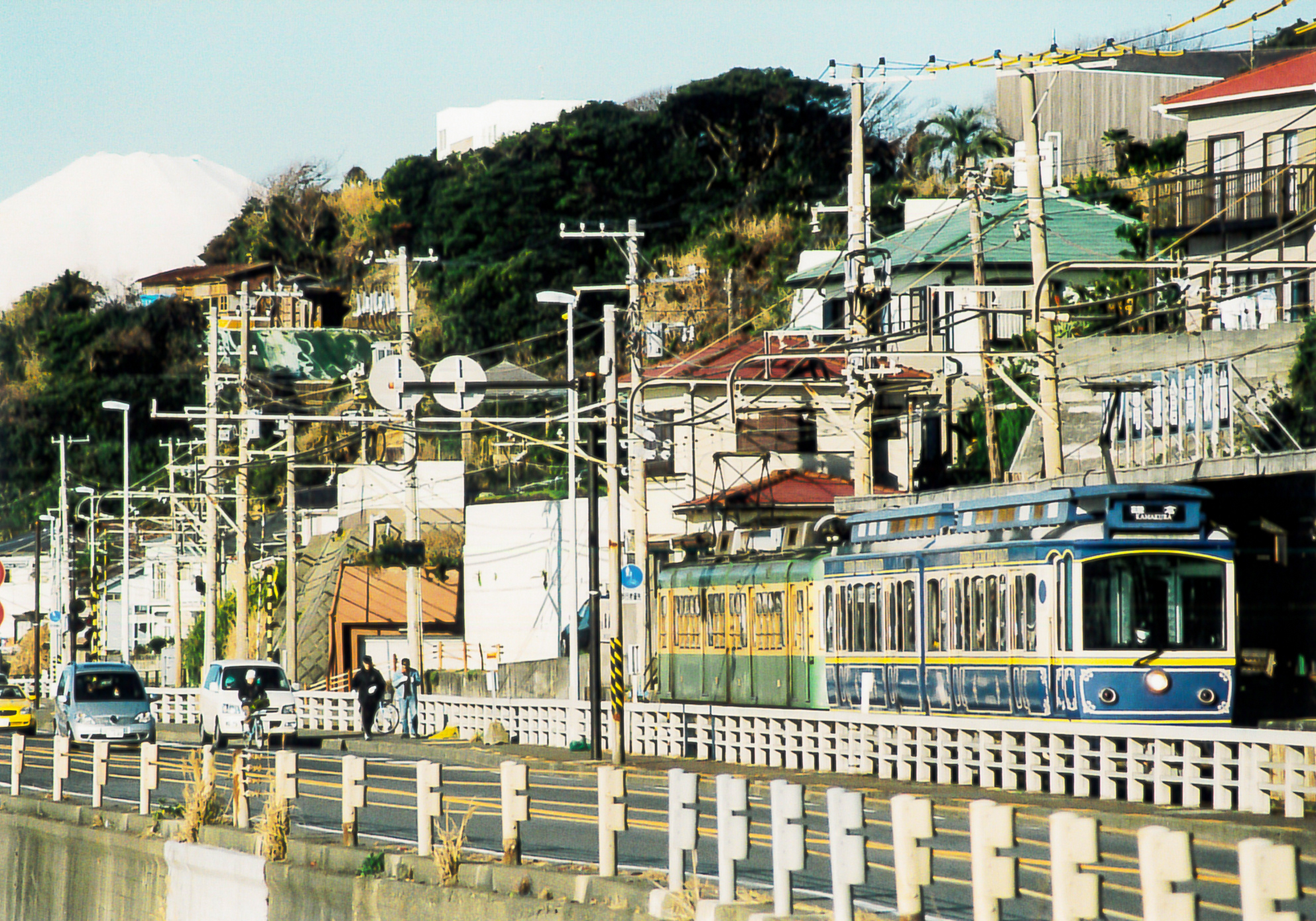 江之電列車駛向鎌倉高校前站，展現沿線街道與列車外觀