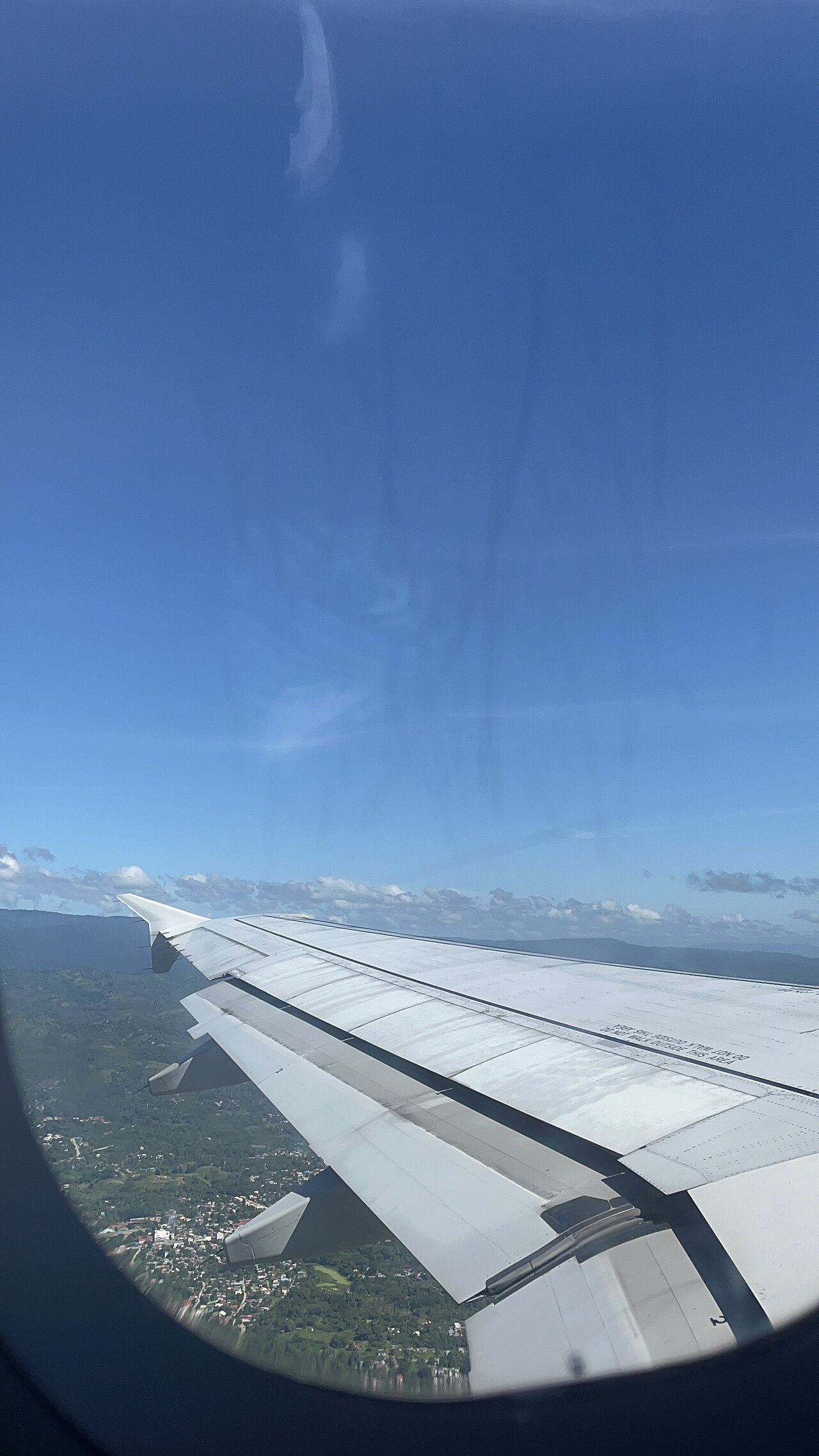 飛機窗外的機翼與天空，僅作機票預訂情境示意