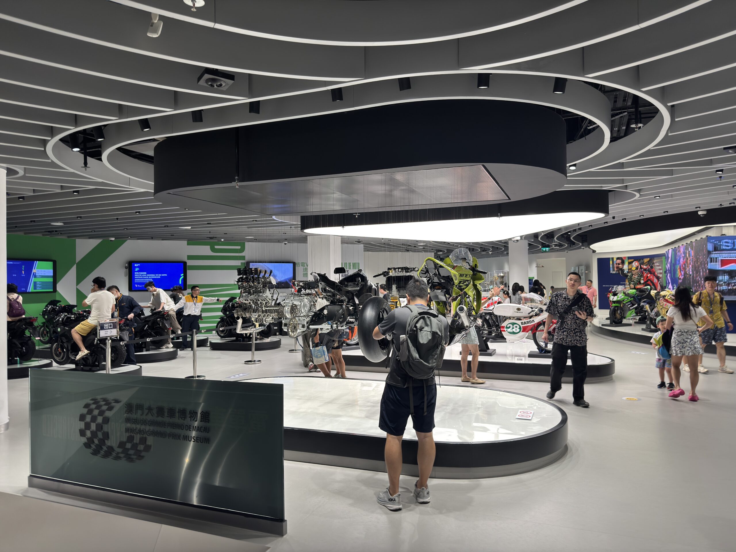 2025年澳門大賽車博物館室內賽車及電單車展品實拍，有參觀者